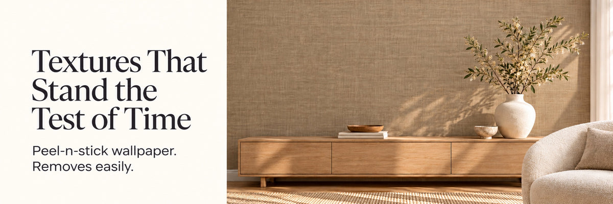 Textured tan peel-and-stick wallpaper behind a wood console with a vase and olive branches